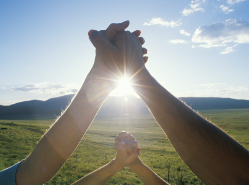 Holding Hands with Sun in the background