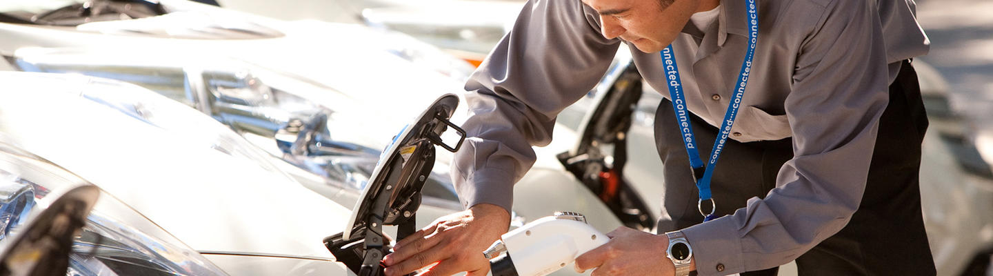 man plugging into ev charger